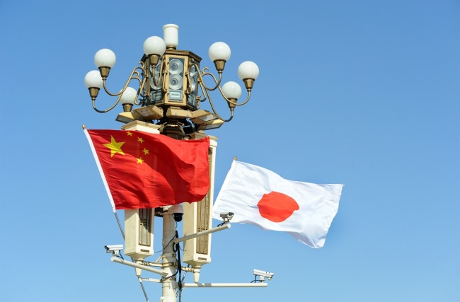 Chinese and Japanese national flags flutter on the lamppost in front of the Tian'anmen Rostrum. [File Photo: IC]