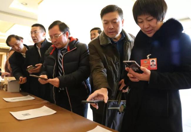 Members scan the QR code to download political consultation APP on their mobile phones in Ningxia in January, 2019. [Photo: nxzx.gov.cn]