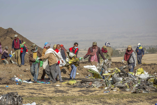 Rescuers work at the scene of an Ethiopian Airlines flight crash near Bishoftu, or Debre Zeit, south of Addis Ababa, Ethiopia, Monday, March 11, 2019. A spokesman says Ethiopian Airlines has grounded all its Boeing 737 Max 8 aircraft as a safety precaution, following the crash of one of its planes in which 157 people were killed. [Photo: AP]