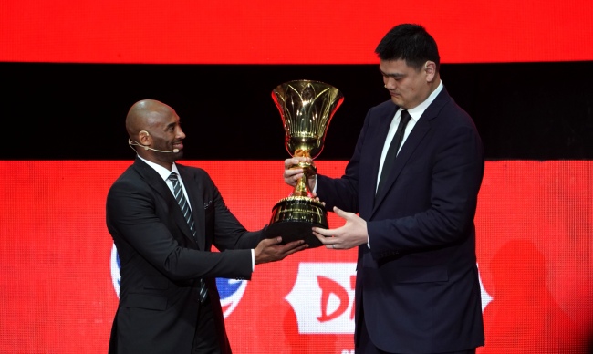Global ambassador for the 2019 FIBA Basketball World Cup Kobe Bryant (L) hands the World Cup trophy to the President of Chinese Basketball Association Yao Ming. [Photo: China Plus]