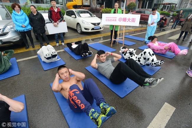 Local residents in sleepwear in Changsha, Hunan province, join a welfare campaign in 2015, educating the public of importance of having a good sleep. [File Photo:VCG]