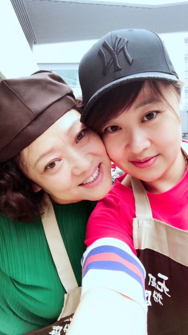 Cui Xinyi and her mum pose for a selfie in her small restaurant in Beijing. [File photo provided for China Plus]