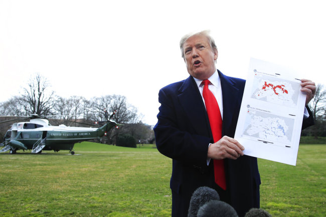 U.S. President Donald Trump shows a map of Syria and Iraq showing the presence of the Islamic State (IS) in 2017 and 2019, as he speaks to reporters before leaving the White House in Washington, Wednesday, March 20, 2019, for a trip to visit an Army tank plant in Lima, Ohio, and a fundraising event in Canton, Ohio. [Photo: AP]