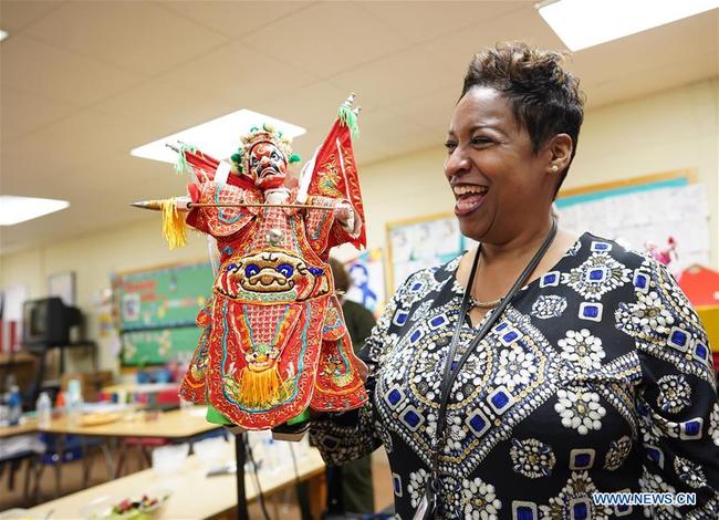 Tricia Hairston, principal of Paint Branch Elementary School, tries to perform Fujian Puppetry at Paint Branch Elementary School in the Prince George's County, Maryland, the United States, March 20, 2019. [Photo: Xinhua]