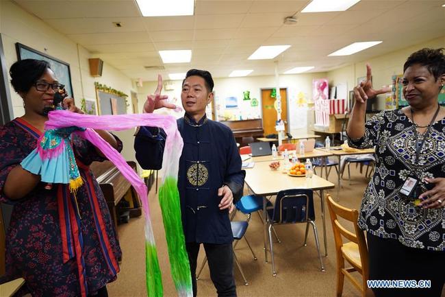 Chen Lihui (C) from Zhangzhou city in southeast China's Fujian province teaches the faculty Fujian Puppetry at Paint Branch Elementary School in the Prince George's County, Maryland, the United States, March 20, 2019. [Photo: Xinhua]