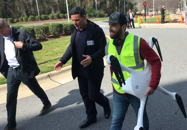 Matternet CEO Andreas Raptopoulos walks next to an operator carrying a drone used for delivery of medical specimens after a flight at WakeMed Hospital in Raleigh, North Carolina on March 26, 2019. Matternet and UPS partnered with the hospital to start commercial flights of medical samples across the WakeMed campus. [Photo: AP]