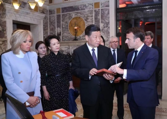 A copy of the first French translation of "An Introduction to the Analects of Confucius" is given to President Xi as a gift to the nation by French President Emmanuel Macron in Nice, France on Sunday, March 24, 2019. [Photo: Xinhua]