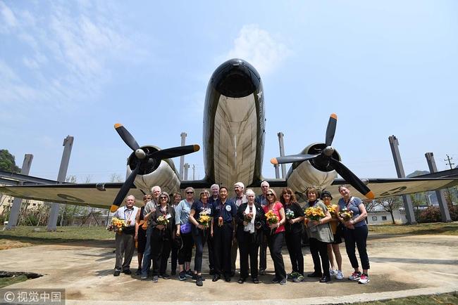 Members of the Flying Tiger Historical Organization and family members of the Flying Tigers pose for photo in front of a C-47 transport plane while visiting the Flying Tiger Heritage Park in Guilin on March 30, 2019. [Photo: VCG]