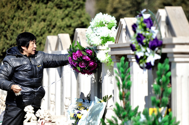 A woman lays flowers at a tomb in Shenyang, Liaoning Province on Mar 31, 2019. [Photo: IC] 