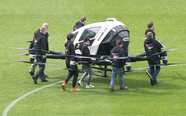 Crew members carry an Air Taxi EHANG 216 during at Generali Arena in Vienna, Austria on April 4, 2019.[Photo:AFP/ JOE KLAMAR]