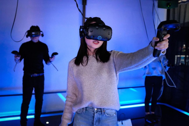 In this photo taken on February 13, 2019, a woman plays a video game using a virtual-reality headset at an arcade in Shanghai. [Photo: AFP/Lianchao Lan]