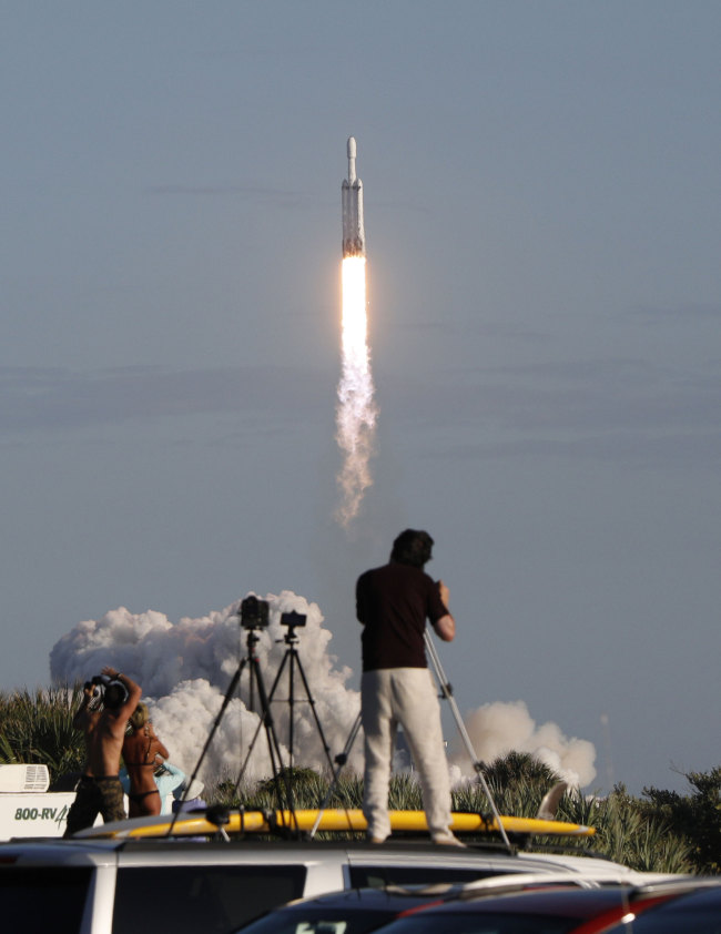 Visitors at Playalinda Beach look on as a SpaceX Falcon Heavy rocket launches from Pad 39B at the Kennedy Space Center in Florida, on April 11, 2019. [Photo: AFP/Gregg Newton] 