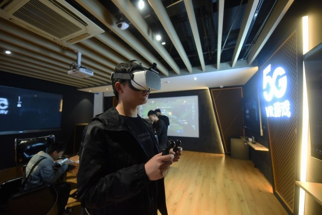 A visitor is wearing a VR headset at a 5G experience hall in Hangzhou, China, April 8, 2019. [Photo:IC]