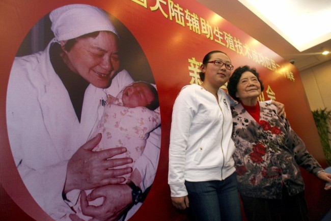 Zheng Mengzhu (L), Chinese mainland's first test-tube baby, poses for photos with Zhang Lizhu, the doctor who delivered her, in Beijing on February 25, 2008. [File photo: The Beijing Times/IC]