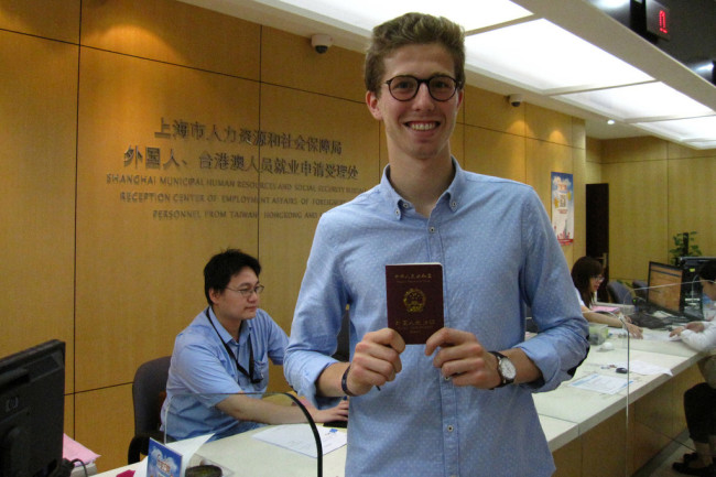 A French national poses with his work card issued by the Shanghai Municipal Human Resources and Social Security Bureau, Shanghai, June 20, 2016. [File Photo: IC]