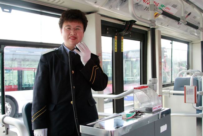 Zhang Hongmei has been a bus conductor with the company for nearly 25 years. [Photo：courtesy of Beijing Public Transport Corporation]
