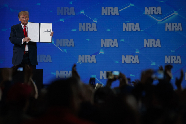 President Donald Trump holds up a letter to the Senate about the UN Arms Trade Treaty as he speaks to the annual meeting of the National Rifle Association, Friday, April 26, 2019, in Indianapolis. [Photo: AP]