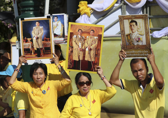 Thai well-wishers hold portrait of Thailand's King Maha Vajiralongkorn outside Grand Palace in Bangkok, Thailand, Saturday, May 4, 2019. [Photo: AP/Sakchai Lalit]