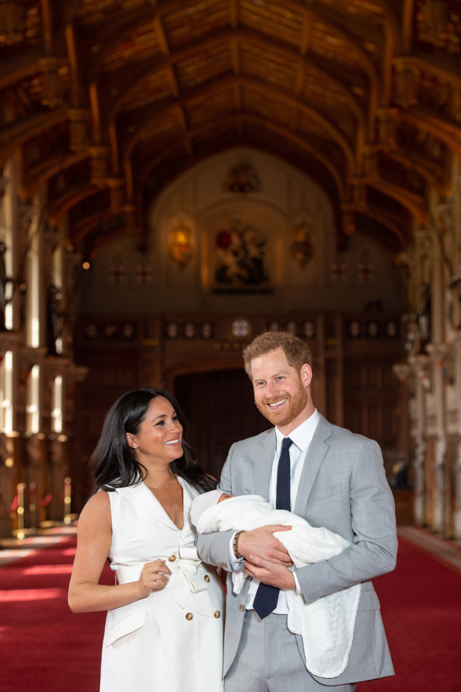 Britain's Prince Harry, Duke of Sussex (R), and his wife Meghan, Duchess of Sussex, pose for a photo with their newborn baby son, Archie Harrison Mountbatten-Windsor, in St George's Hall at Windsor Castle in Windsor, west of London on May 8, 2019. [Photo: AFP]