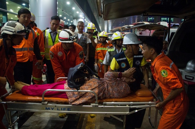Rescue workers transport an injury passenger on a stretcher after a passenger aircraft of Biman Bangladesh airlines slipped off a runway at Yangon International airport in Yangon on May 8, 2019. [Photo: AFP]