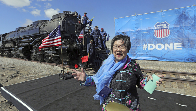 Margaret Yee, whose ancestors helped build the railroad, pose in front of the the Big Boy, No. 4014 during the commemoration of the 150th anniversary of the Transcontinental Railroad completion at Union Station Thursday, May 9, 2019, in Ogden, Utah. Yee, helped tap a ceremonial spike alongside Utah Gov. Gary Herbert and a descendant of Union Pacific's chief engineer on the project at the event Thursday in Ogden, Utah. [Photo: AP/Rick Bowmer]