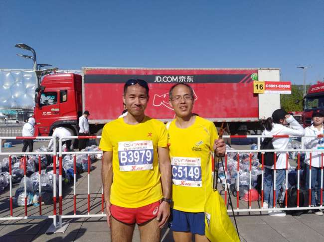 Mori Masatsugu (L) poses for a photo with his friend after they finish a half marathon competition in Beijing on April 4, 2019. [File Photo provided for China Plus]
