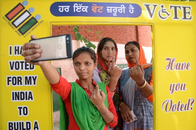 Indian voters pose for a picture as they show their ink-marked finger after casting their vote at a polling centre on the outskirts of Amritsar on May 19, 2019, during the 7th and final phase of India's general election. [Photo: AFP]