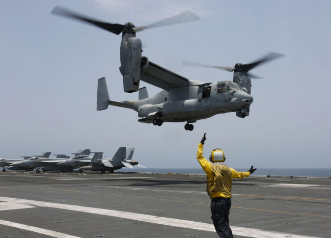 In this Friday, May 17, 2019, photo released by the U.S. Navy, Aviation Boatswain's Mate 2nd Class Nicholas Hawkins, from Houston, Texas, signals an MV-22 Osprey to land on the flight deck of the Nimitz-class aircraft carrier USS Abraham Lincoln in the Arabian Sea. [Photo: Mass Communication Specialist 3rd Class Amber Smalley/U.S. Navy via AP]