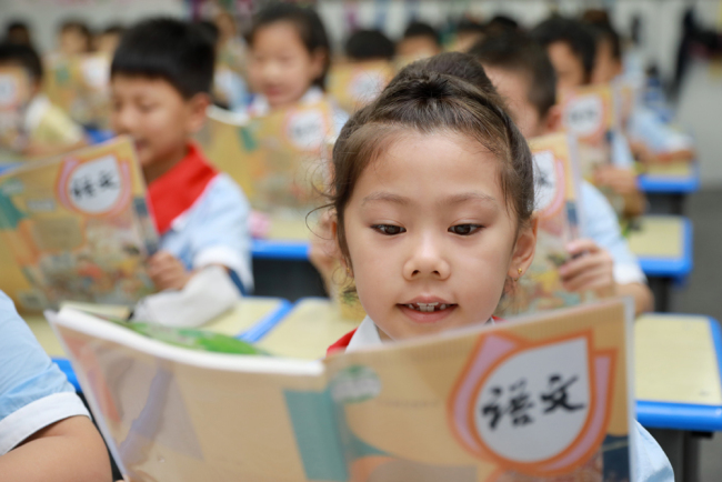 A student reads a textbook at a primary school in Lianyungang, Jiangsu Province, September 3, 2018. [File Photo: IC]