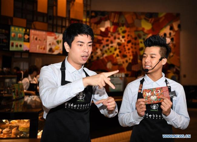 Staff members practice sign language in a Starbucks coffee store in Guangzhou, south of China's Guangdong Province, May 19, 2019. [Photo: Xinhua]
