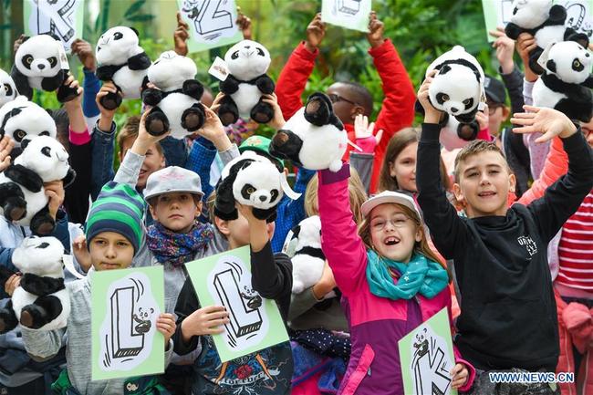 Children wave panda toys to welcome giant panda Yuan Yuan at the Schoenbrunn Zoo in Vienna, Austria, on May 20, 2019. [Photo: Xinhua]