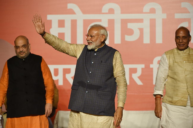 India Prime Minister Narendra Modi (C) gestures to supporters next to Bharatiya Janta Party (BJP) president Amit Shah (L) and Minister of Home Affairs of India Rajnath Singh as they celebrate the victory in India's general election at the party headquarters in New Delhi on May 23, 2019. [Photo: AFP]