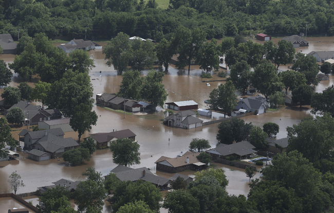 In this aerial image, homes are inundated with flood waters from the Arkansas River near South 145th West Ave near Highway 51 on Thursday, May 23, 2019, in Sand Springs, Oklahoma. Storms and torrential rains have ravaged the Midwest, from Texas through Oklahoma, Kansas, Nebraska, Iowa, Missouri and Illinois, in the past few days. [Photo: AP]