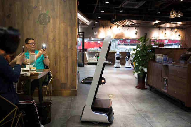 Robots serving food in a restaurant in Binhai New Area. [Photo: People's Daily Online/Tanja Herko]