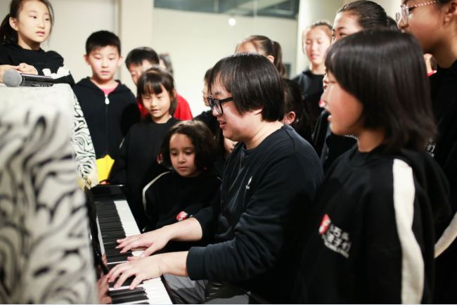 Shi Dongying was playing the piano and some members of Stone and Children Band were singing with him. [Photo: courtesy of Shi Dongying, music producer of Stone and Children Band]