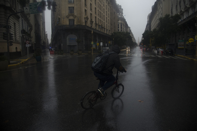 A man rides a bike in front the Obelisk, during the black out and under a heavy rain, in Buenos Aires, Argentina, Sunday, June 16, 2019. [Photo: VCG]