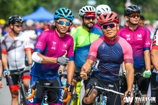 Cyclists pose for photos ahead of the 2019 Zhejiang Great Bay Area Cycling Open second leg race in Wencheng, Wenzhou on Jun 16, 2019. [Photo provided to China Plus]