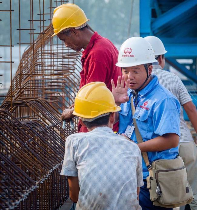 Thirty-nine year old Xu Luping (in blue shirt), now an expert in making precast box-girders, left his rural home at sixteen and has since worked at various construction sites as a migrant worker. [Photo: courtesy of China Tiesiju Civil Engineering Group]