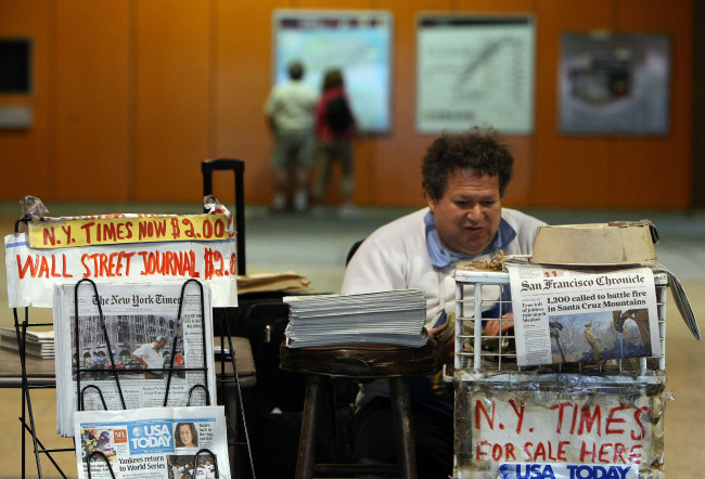 Newspaper vendor Rick Gaub waits for customers at his stand in an underground rail station October 26, 2009 in San Francisco, California. [File photo: VCG]