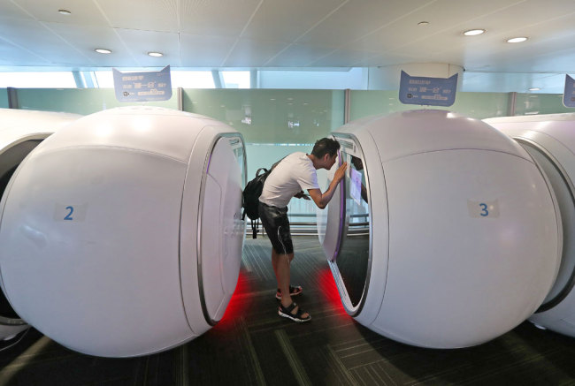 A traveler looks into a capsule at Terminal 3 at Hangzhou Xiaoshan International Airport on June 23, 2019. [Photo: IC]