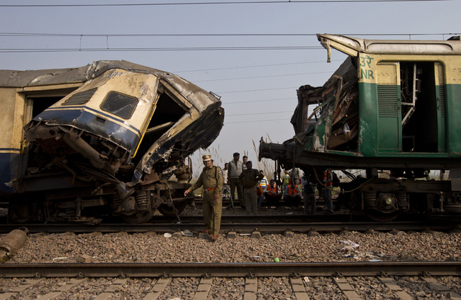 Railway workers, policemen and onlookers surround the destroyed coaches after two trains collided at Janauli in the northern state of Haryana, India, on December 8, 2015. [File Photo: IC]