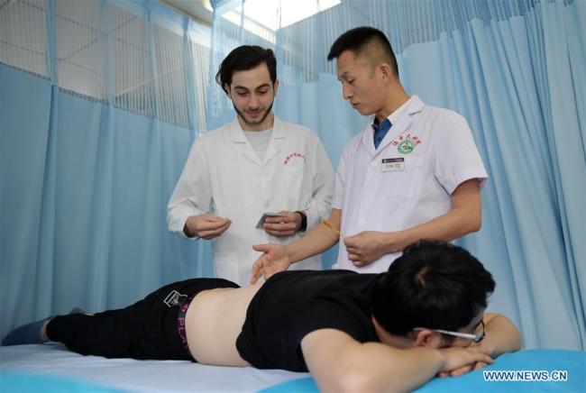 Aushev Djamaleil (L) practices acupuncture at the Affiliated Hospital of Shaanxi University of Chinese Medicine in northwest China's Shaanxi Province. [Photo: Xinhua] 