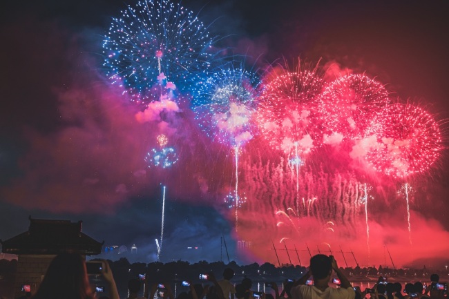 Local residents gather to watch fireworks exploding in the sky over the Xiangjiang River in a ceremony to celebrate the first China-Africa Economic and Trade Expo in Changsha city, central China's Hunan province, June 26, 2019. [Photo: IC]