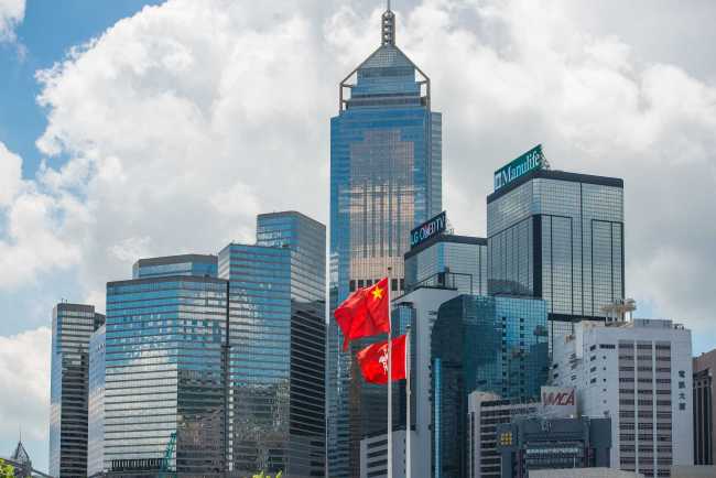 The national flag of China and the regional flag of the Hong Kong Special Administrative Region fly in front of the government building in Hong Kong. [File photo: VCG]