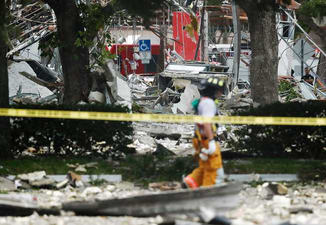 A firefighter walks in front of the remains of a building after an explosion on Saturday, July 6, 2019, in Plantation, Fla. [Photo: IC]