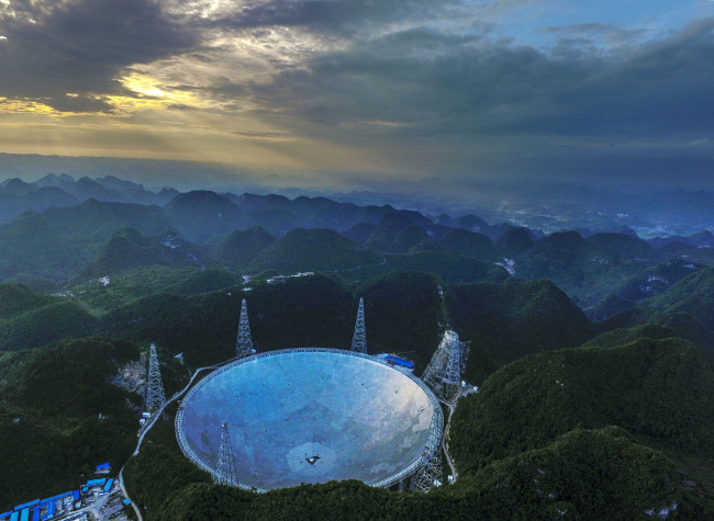Aerial view of the world's largest radio telescope called FAST (Five-hundred-meter Aperture Spherical Telescope) in Pingtang County, Qiannan Buyi and Miao Autonomous Prefecture, Guizhou Province, June 10, 2016. [File photo: IC]