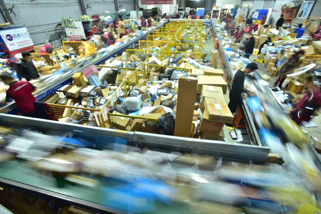 Chinese workers sort out parcels at a distribution center in the city of Neijiang, Sichuan province, 16 November 2018. [File photo: IC]