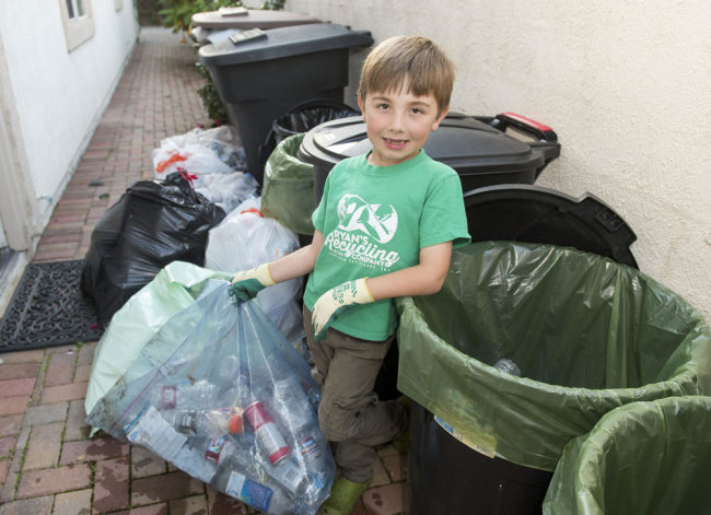 Ryan Hickman poses for a photo in his recycling(回收 huíshōu) and sorting(分类 fēnlèi) station in the side yard of his parent's home in San Juan Capistrano, California, on Tuesday, February 28, 2017. [File Photo: IC]