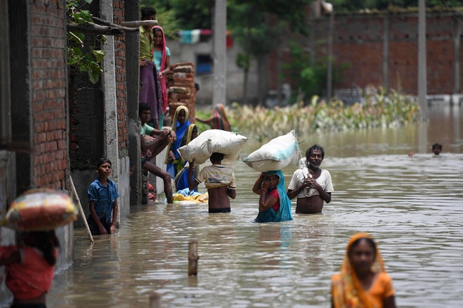 Indian residents wade along a flooded street carrying their belongings following heavy monsoon rains at Sitamarhi district in the Indian state of Bihar on July 17, 2019. [Photo: VCG/AFP/Sachin Kumar]