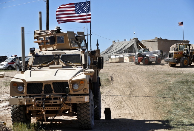 A U.S. soldier sits on an armored vehicle behind a sand barrier at a newly installed position near the front line between the U.S-backed Syrian Manbij Military Council and the Turkish-backed fighters, in Manbij, north Syria, April 4, 2018. [File photo: IC]